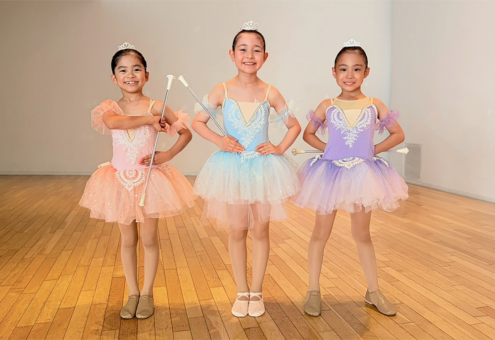 バトンを持って笑顔でポーズをとるDream Baton Twirlersの生徒3人
